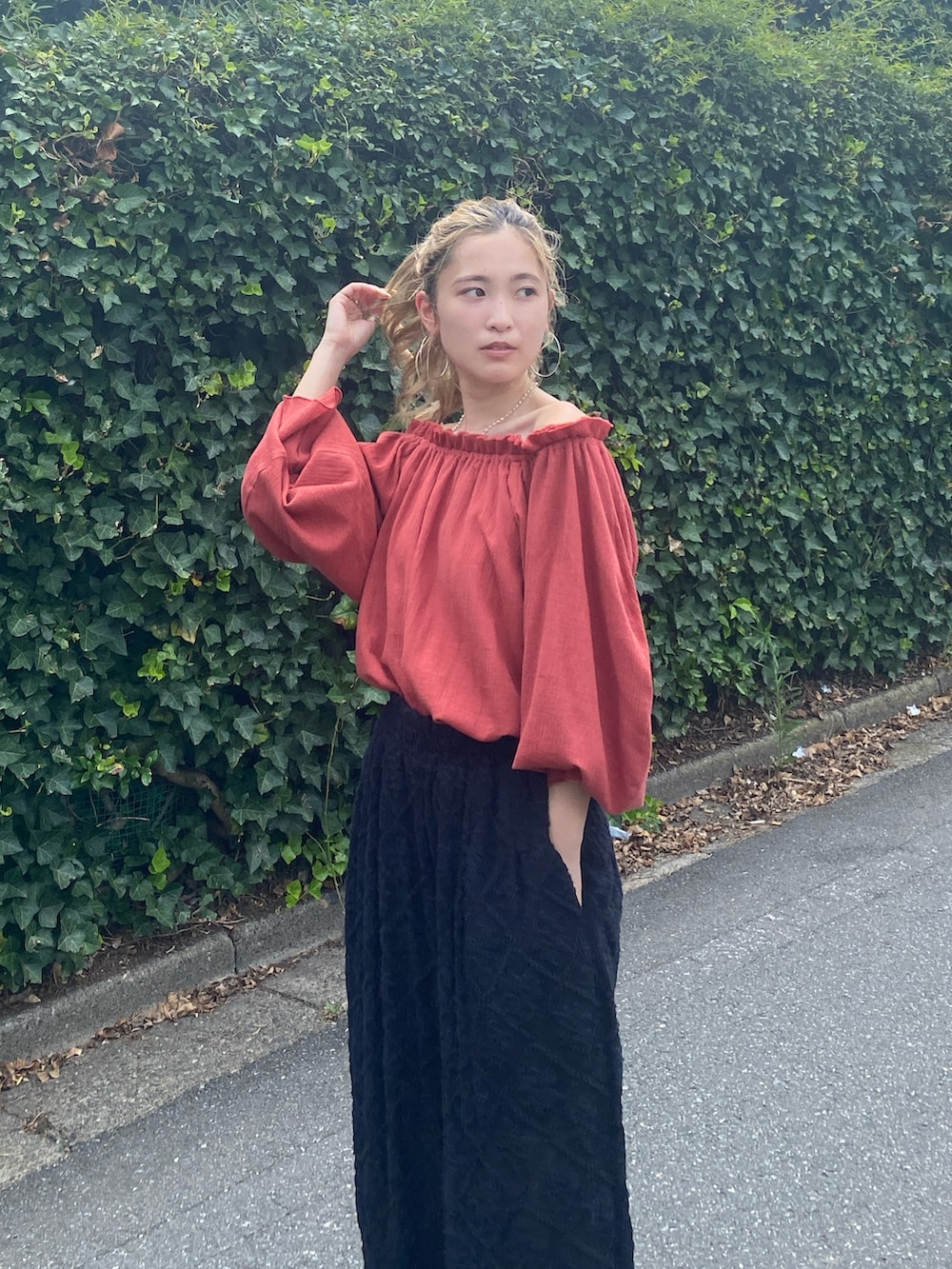 オレンジ系のシャツ/ブラウス、ブラック系のその他パンツを着用したレディースの秋コーディネートの6枚目の写真