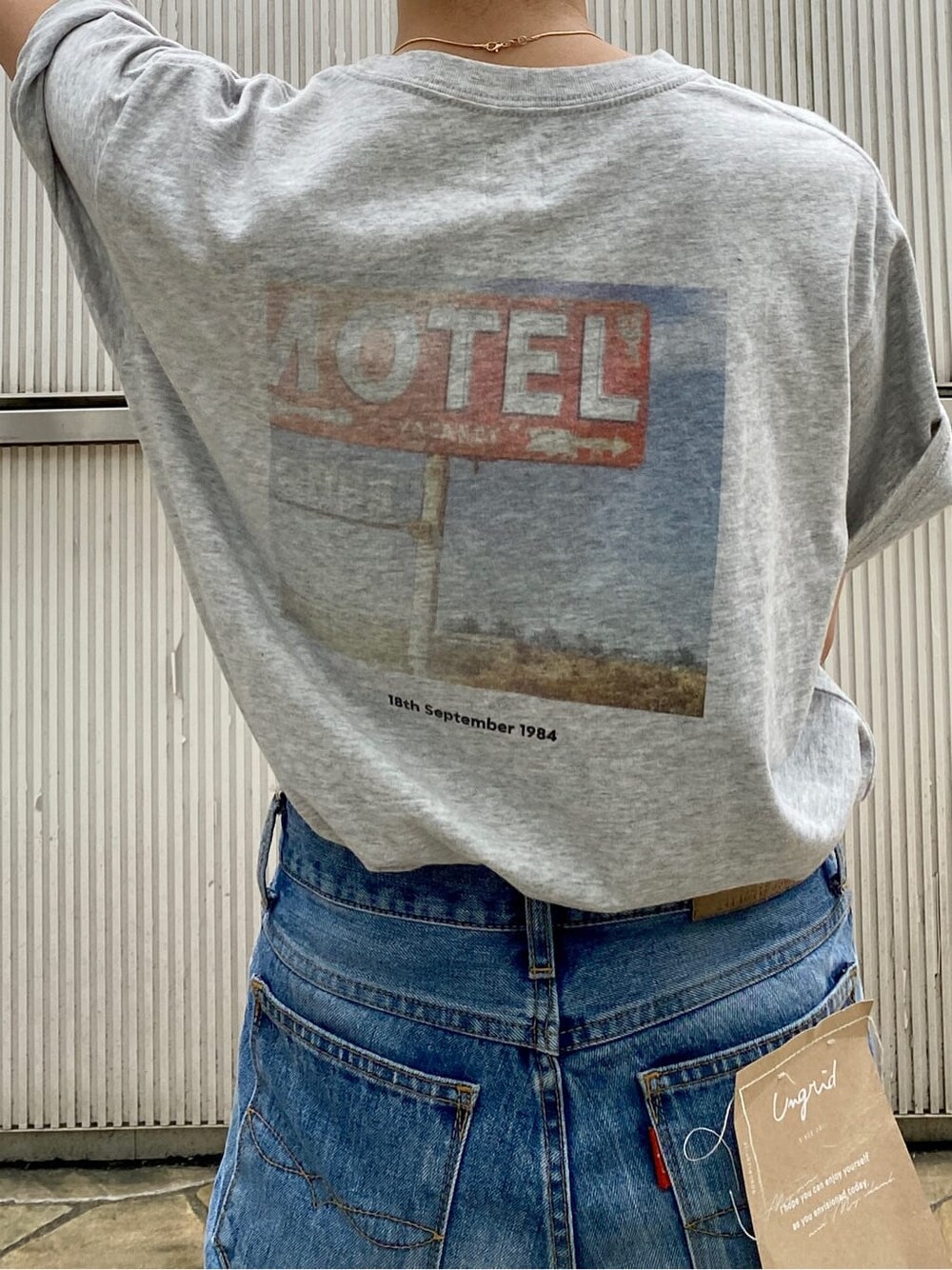 ブルー系のデニムパンツ、ブラック系のサンダル、グレー系のTシャツ/カットソーを着用したレディースの夏コーディネートの6枚目の写真