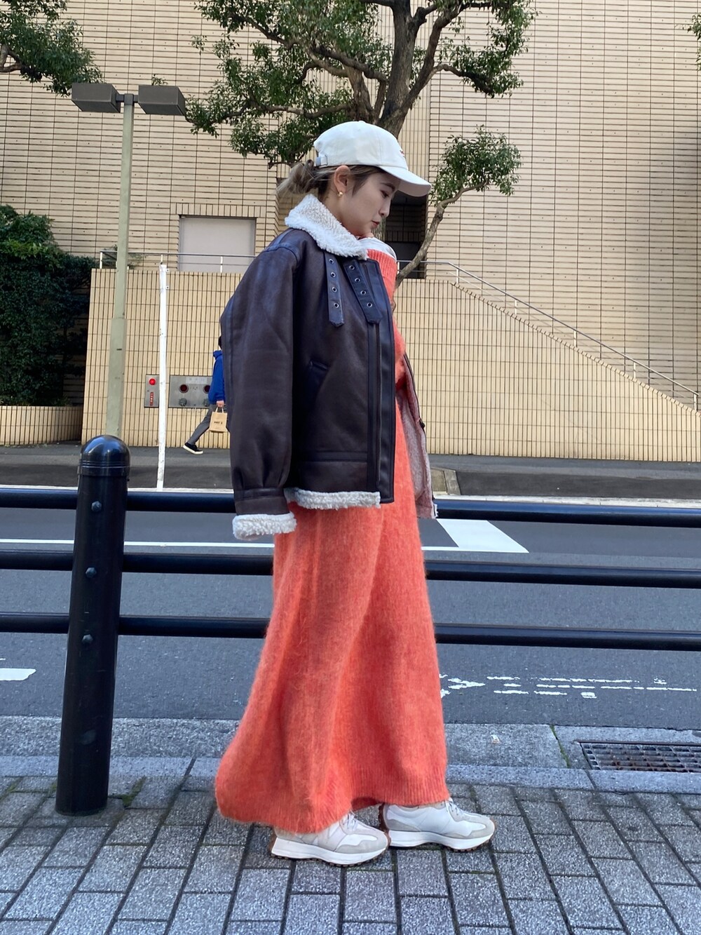 オレンジ系のワンピース、ブラウン系のブルゾン、ホワイト系のTシャツ/カットソーを着用したレディースの冬コーディネートの5枚目の写真