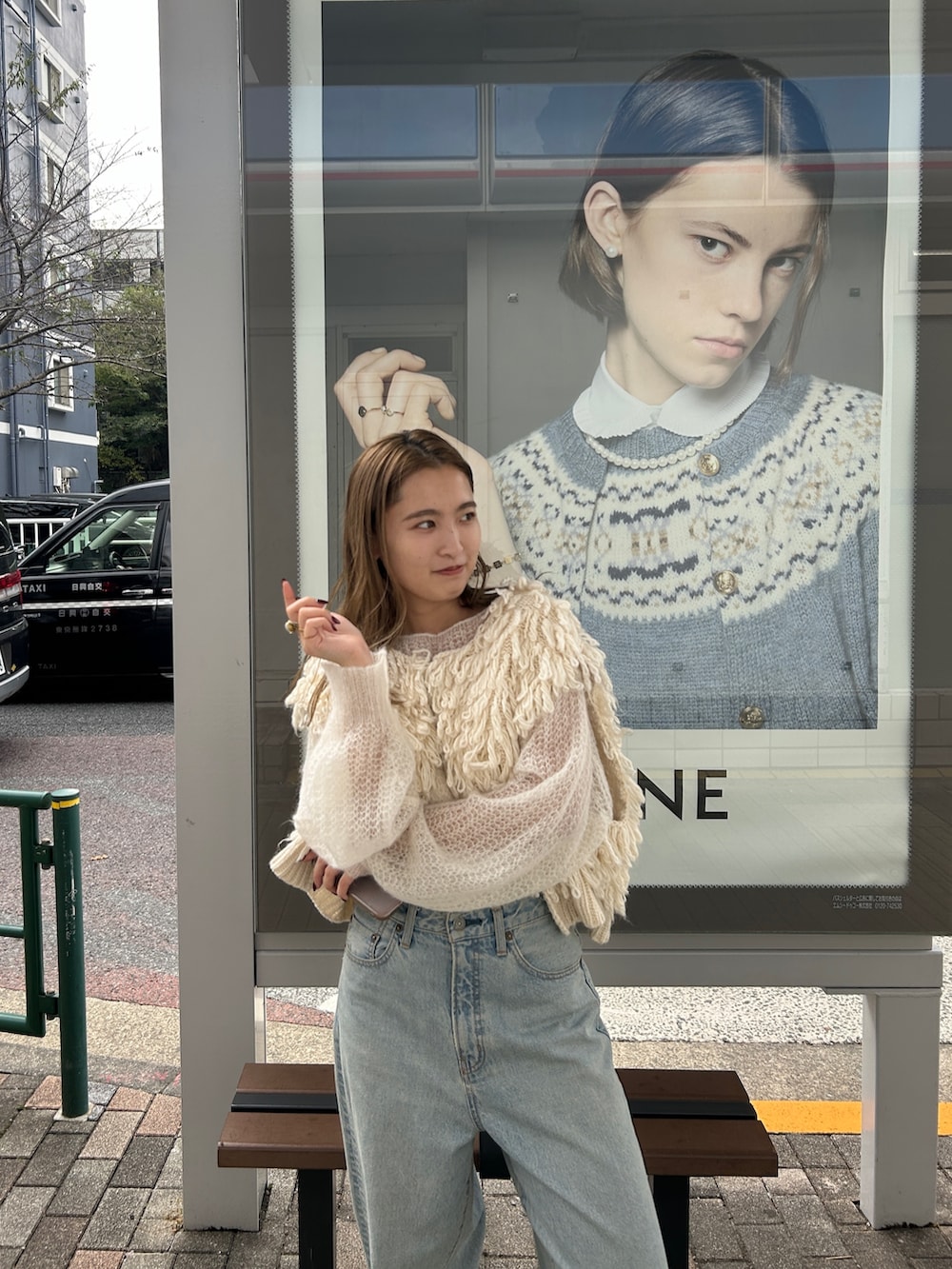 ホワイト系のベスト、ホワイト系のニット/セーター、ブルー系のデニムパンツを着用したレディースの秋コーディネートの5枚目の写真