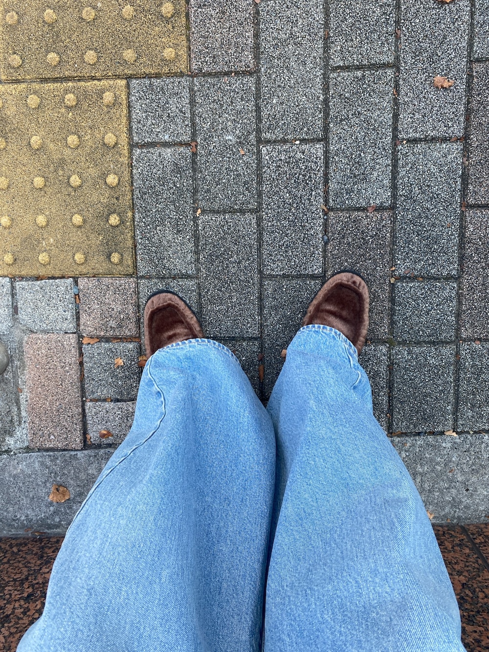 ホワイト系のシャツ/ブラウス、ブルー系のデニムパンツ、ブラウン系のローファーを着用したレディースの秋コーディネートの4枚目の写真