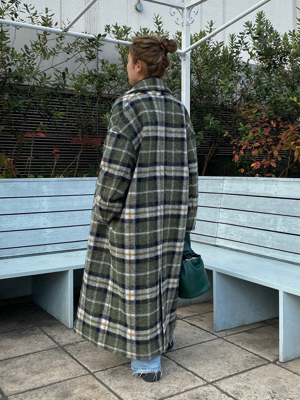 ブルー系のデニムパンツ、ブラック系のニット/セーター、その他のチェスターコートを着用したレディースの秋コーディネートの3枚目の写真