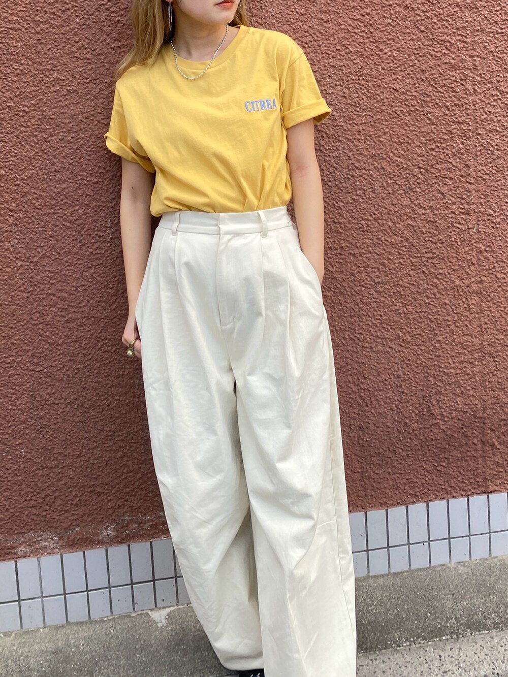 イエロー系のTシャツ/カットソー、ホワイト系のチノパンツを着用したレディースの夏コーディネートの4枚目の写真