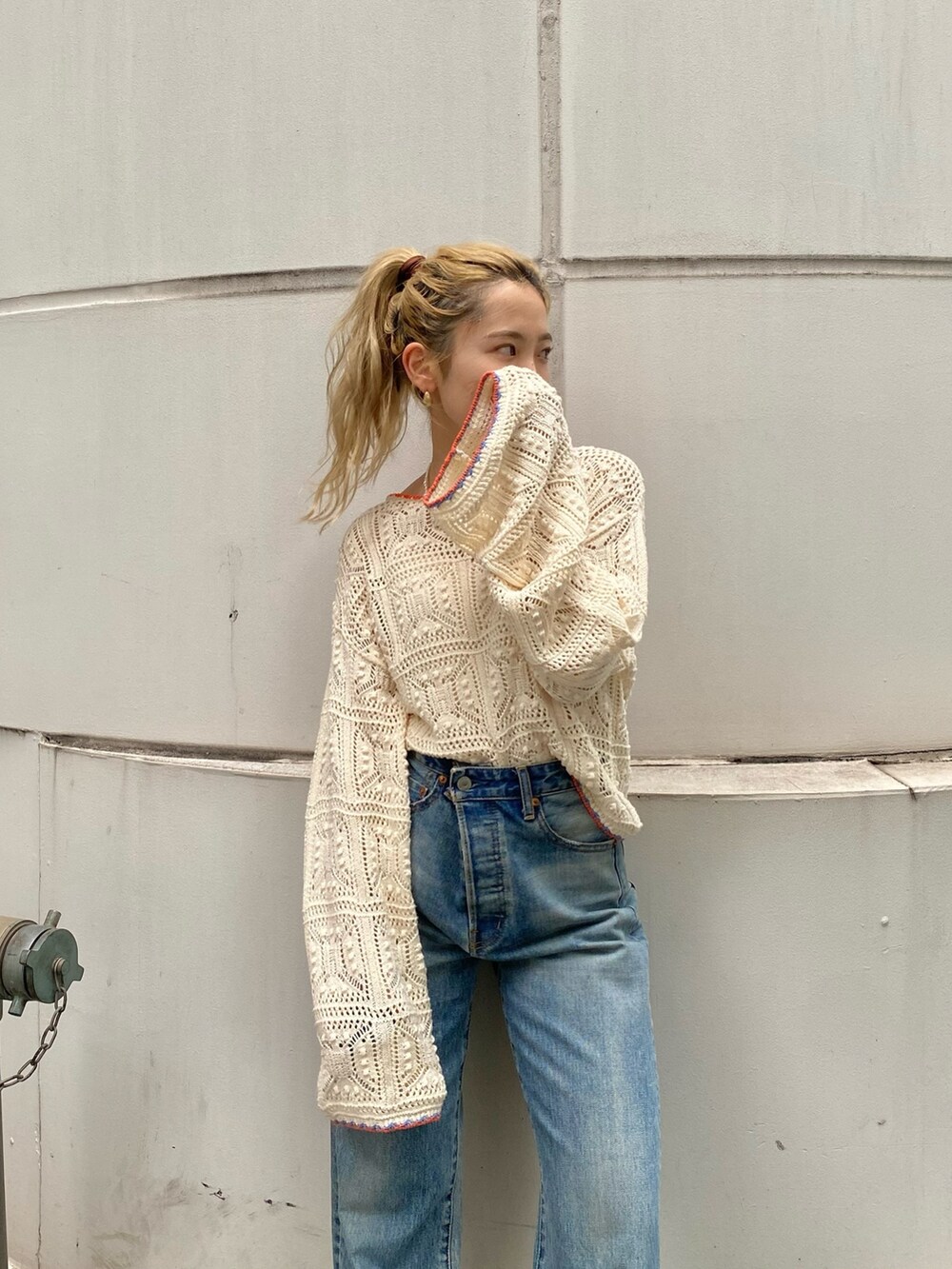 ホワイト系のキャミソール、ホワイト系のニット/セーター、ブルー系のデニムパンツを着用したレディースの夏コーディネートの3枚目の写真