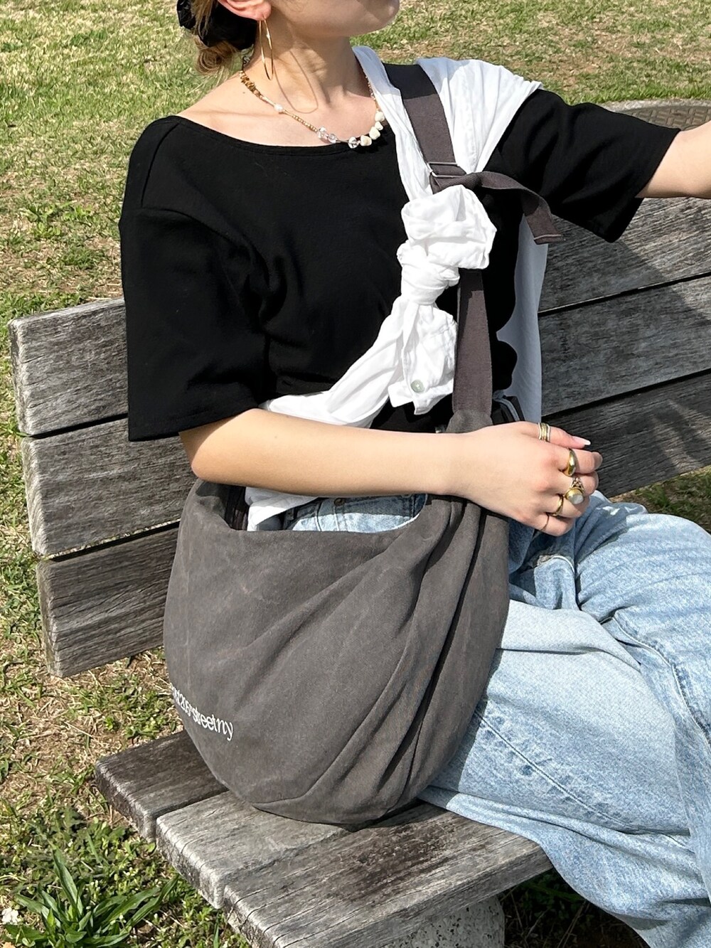 ブラック系のTシャツ/カットソー、ホワイト系のシャツ/ブラウス、グレー系のハンドバッグを着用したレディースの春コーディネートの3枚目の写真