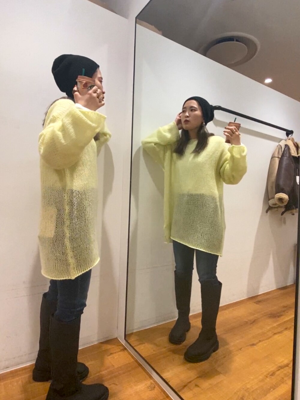 イエロー系のニット/セーター、ホワイト系のTシャツ/カットソー、ブラック系のブーツを着用したレディースの秋コーディネートの2枚目の写真