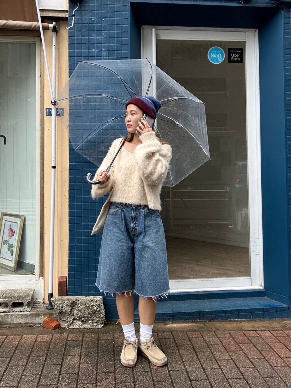 ホワイト系のニット/セーター、ブルー系のデニムパンツ、レッド系のニットキャップ/ビーニーを着用したレディースの秋コーディネートの2枚目の写真