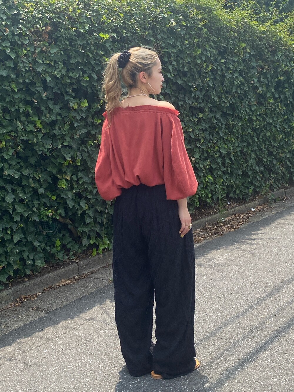 オレンジ系のシャツ/ブラウス、ブラック系のその他パンツを着用したレディースの秋コーディネートの3枚目の写真