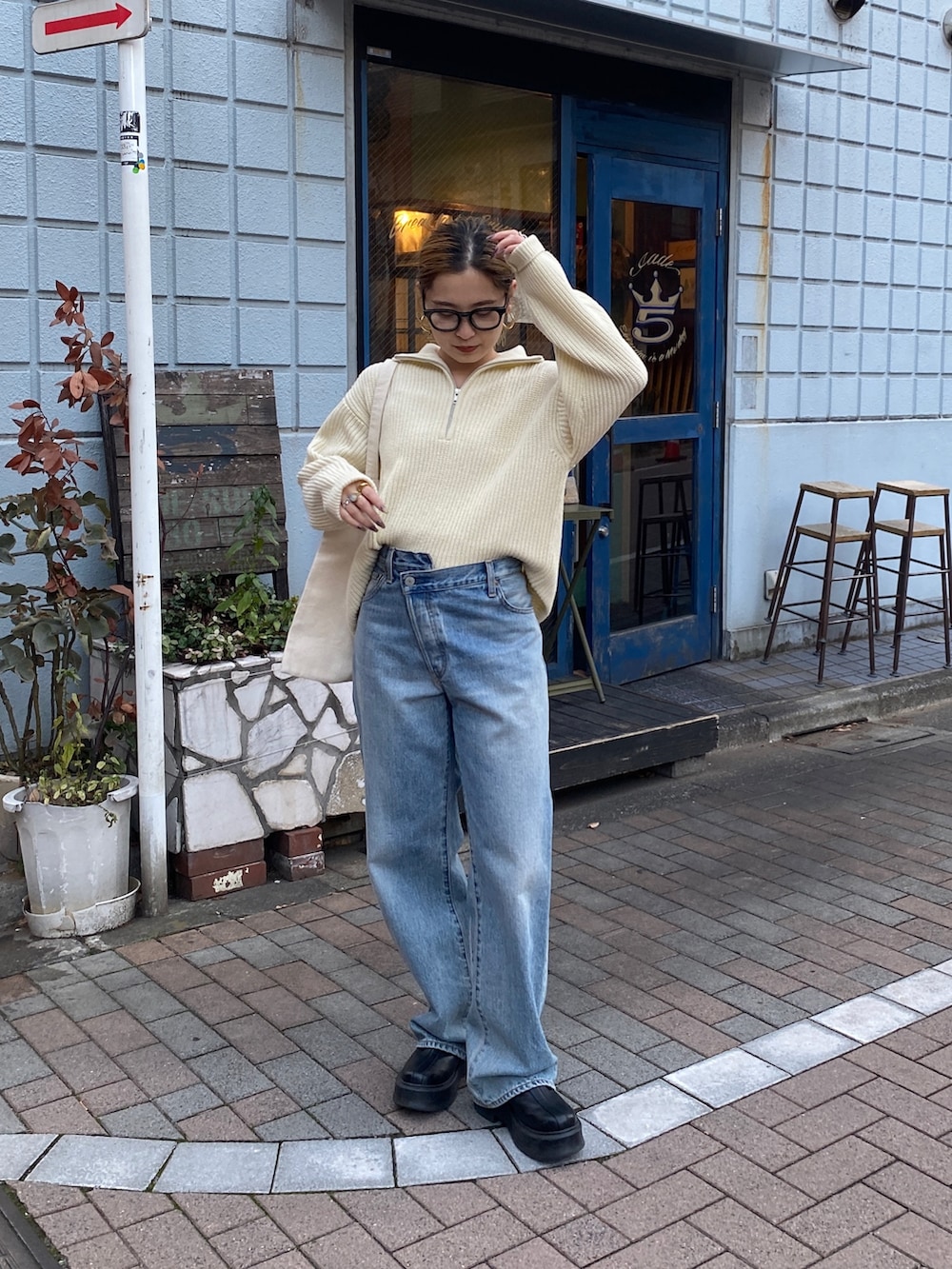 ホワイト系のニット/セーター、ブルー系のデニムパンツ、レッド系のトートバッグを着用したレディースの冬コーディネートの5枚目の写真