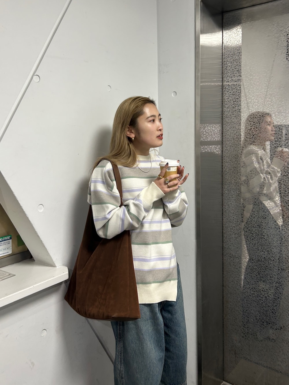 ホワイト系のニット/セーター、ブルー系のデニムパンツを着用したレディースの春コーディネートの4枚目の写真