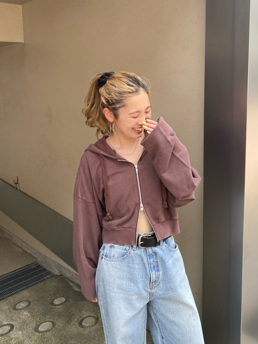 ブラウン系のパーカー、ブルー系のデニムパンツ、ブラウン系のローファーを着用したレディースの秋コーディネートの3枚目の写真