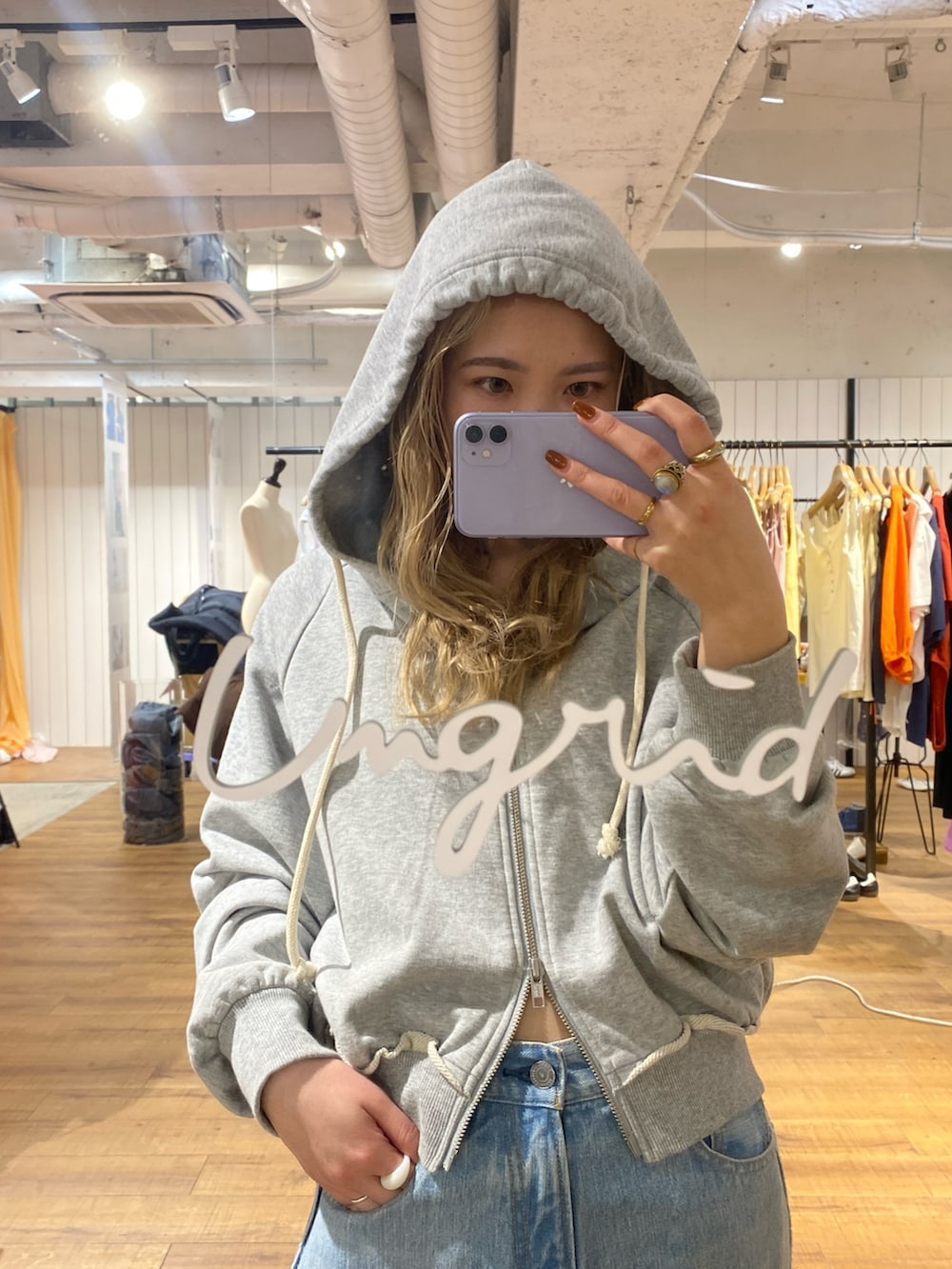 グレー系のパーカー、ブルー系のデニムパンツを着用したレディースの冬コーディネートの3枚目の写真