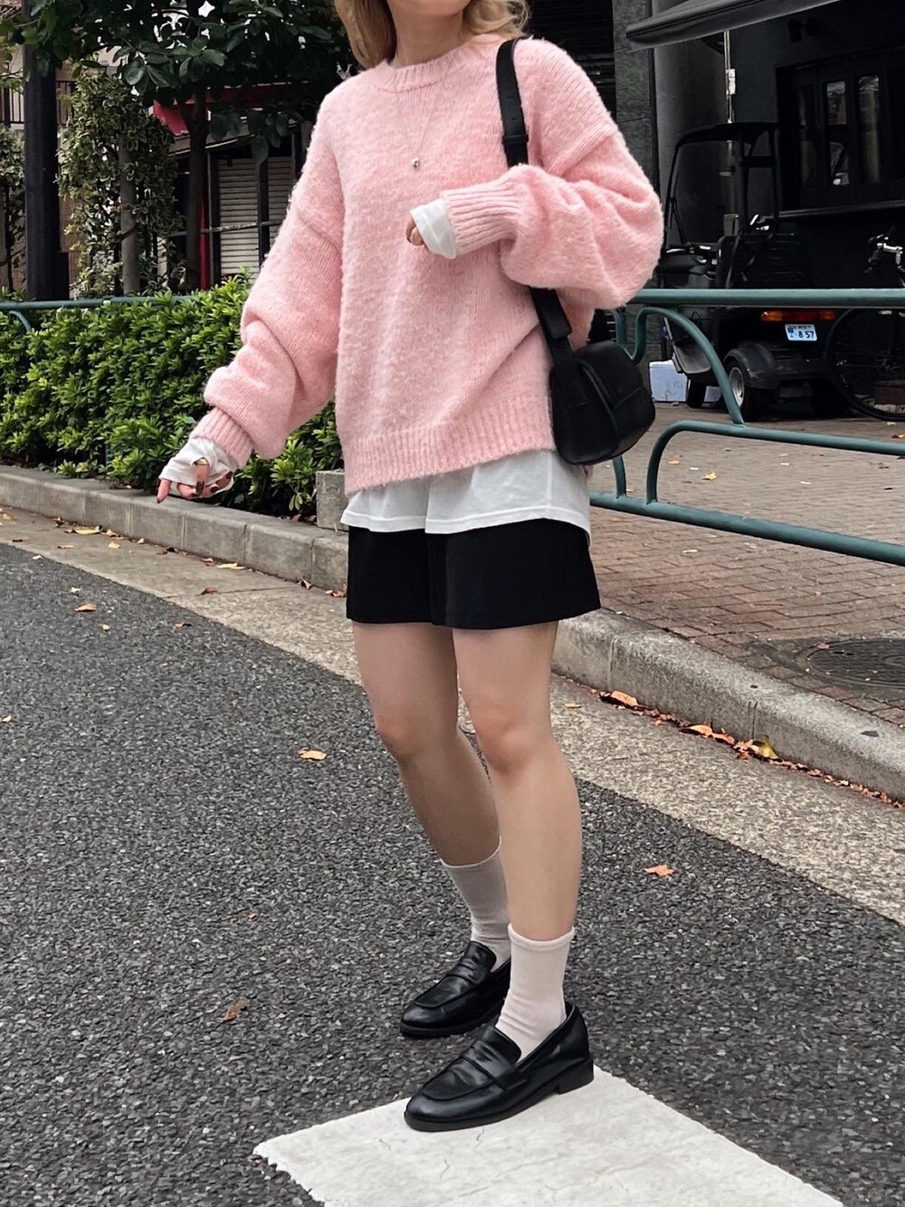 ピンク系のニット/セーター、ブラック系のローファー、ブラック系のショルダーバッグを着用したレディースの秋コーディネートの4枚目の写真