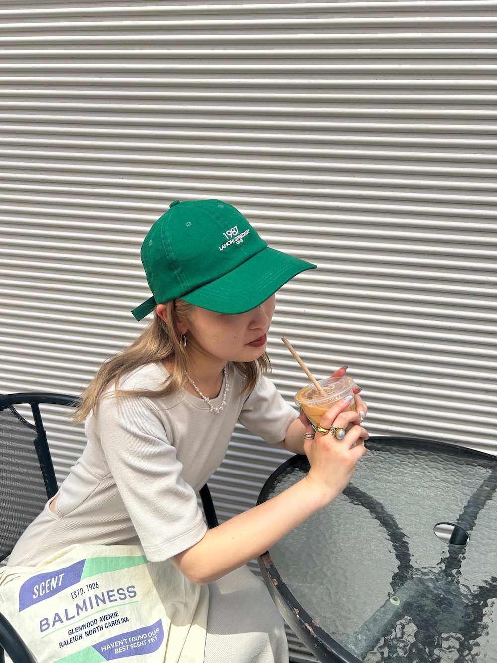 グレー系のワンピース、グリーン系のキャップを着用したレディースの夏コーディネートの4枚目の写真