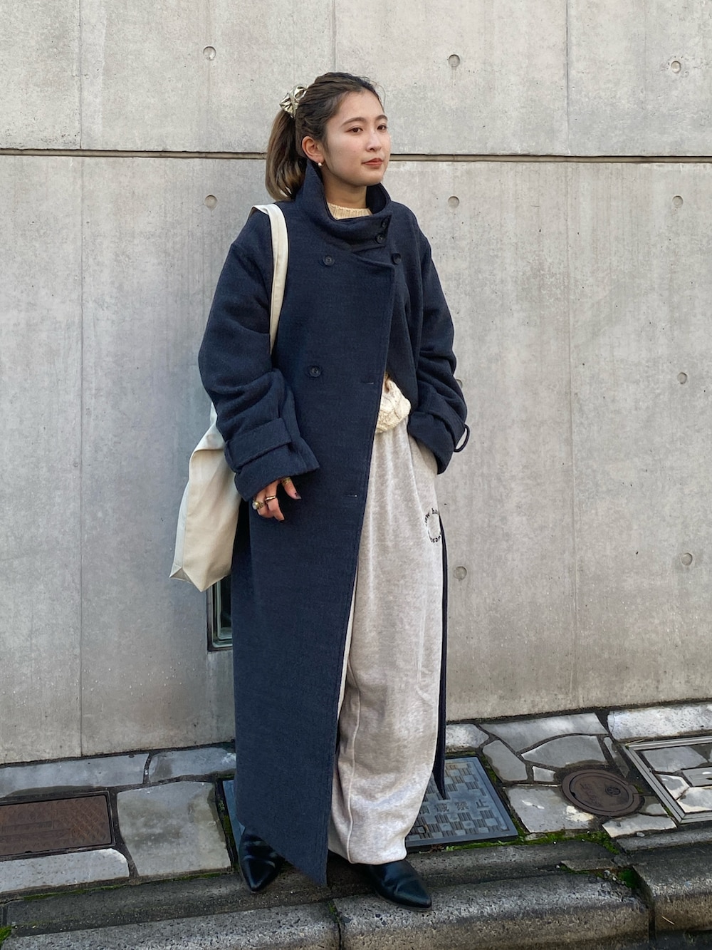 グレー系のその他アウター、グレー系のスウェットパンツ、ホワイト系のニット/セーターを着用したレディースの冬コーディネートの3枚目の写真