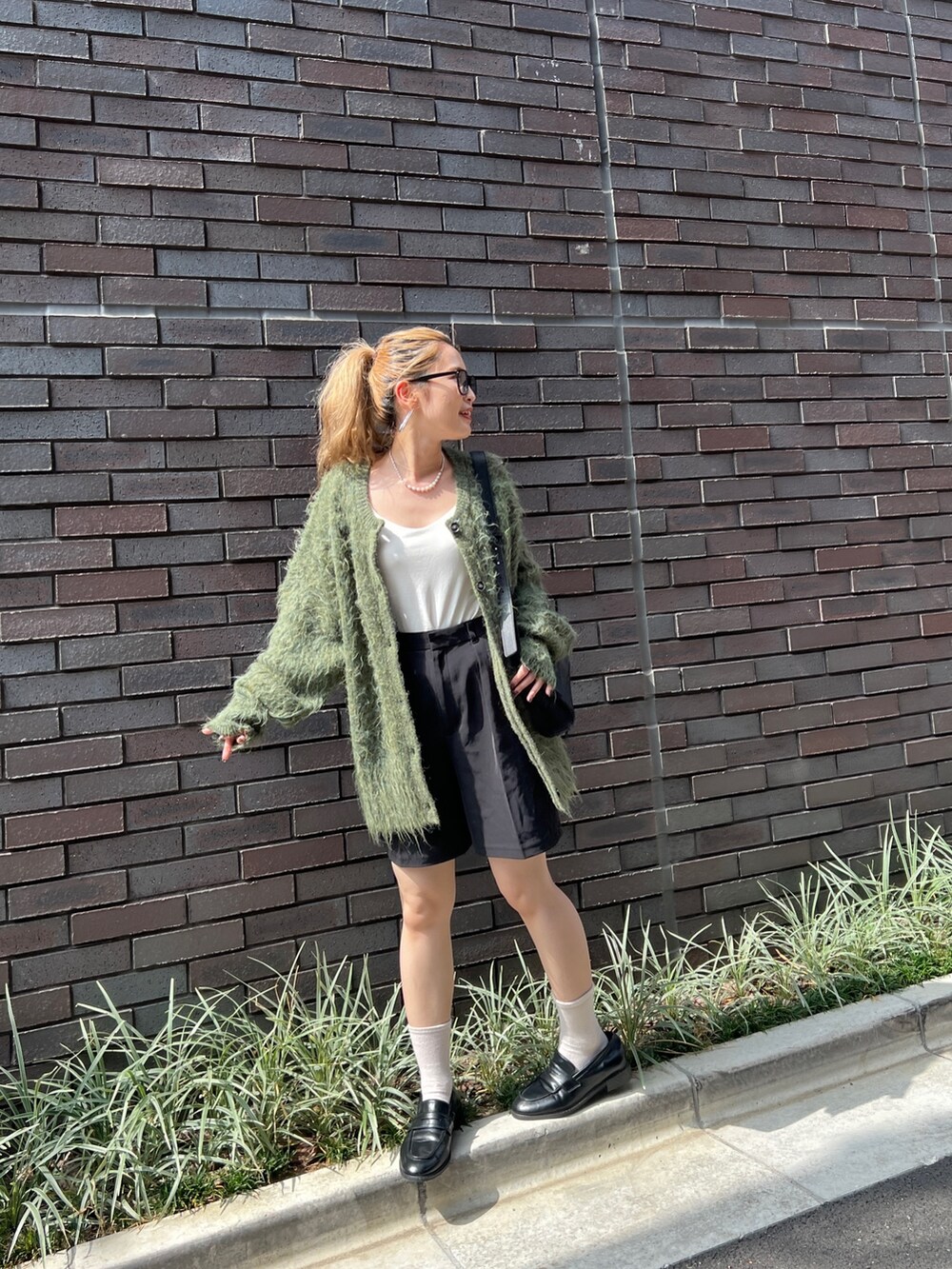 グリーン系のカーディガン/ボレロ、ブラック系のショルダーバッグ、ブラック系のローファーを着用したレディースの秋コーディネートの3枚目の写真