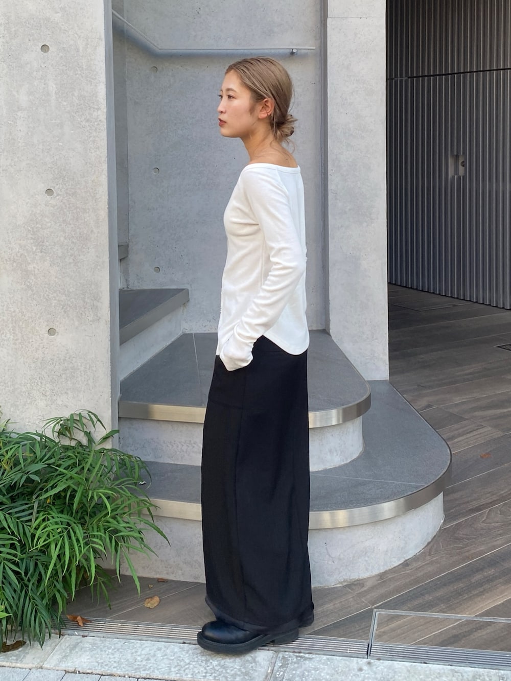 ホワイト系のTシャツ/カットソー、ブラック系のスカート、ブラック系のブーツを着用したレディースの秋コーディネートの2枚目の写真