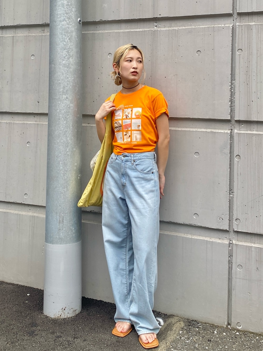 オレンジ系のTシャツ/カットソー、ブルー系のデニムパンツ、その他のサンダルを着用したレディースの春コーディネートの2枚目の写真