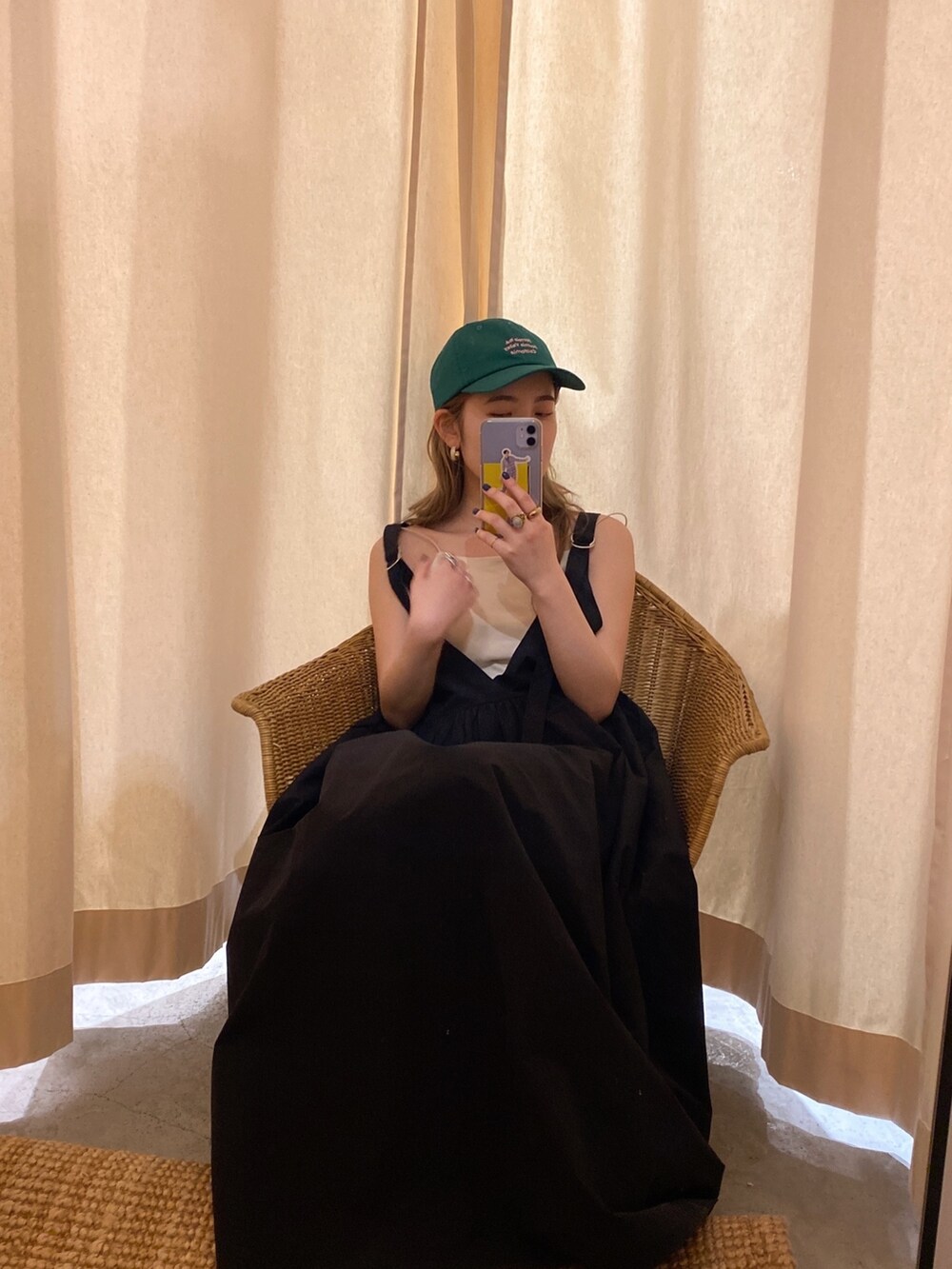 ブラック系のワンピース、ホワイト系のキャミソール、グリーン系のキャップを着用したレディースの春コーディネートの5枚目の写真