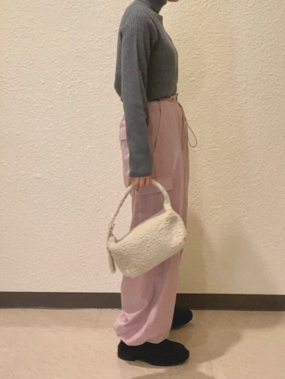 グレー系のニット/セーター、ピンク系のカーゴパンツ、ホワイト系のハンドバッグを着用したレディースの冬コーディネートの3枚目の写真