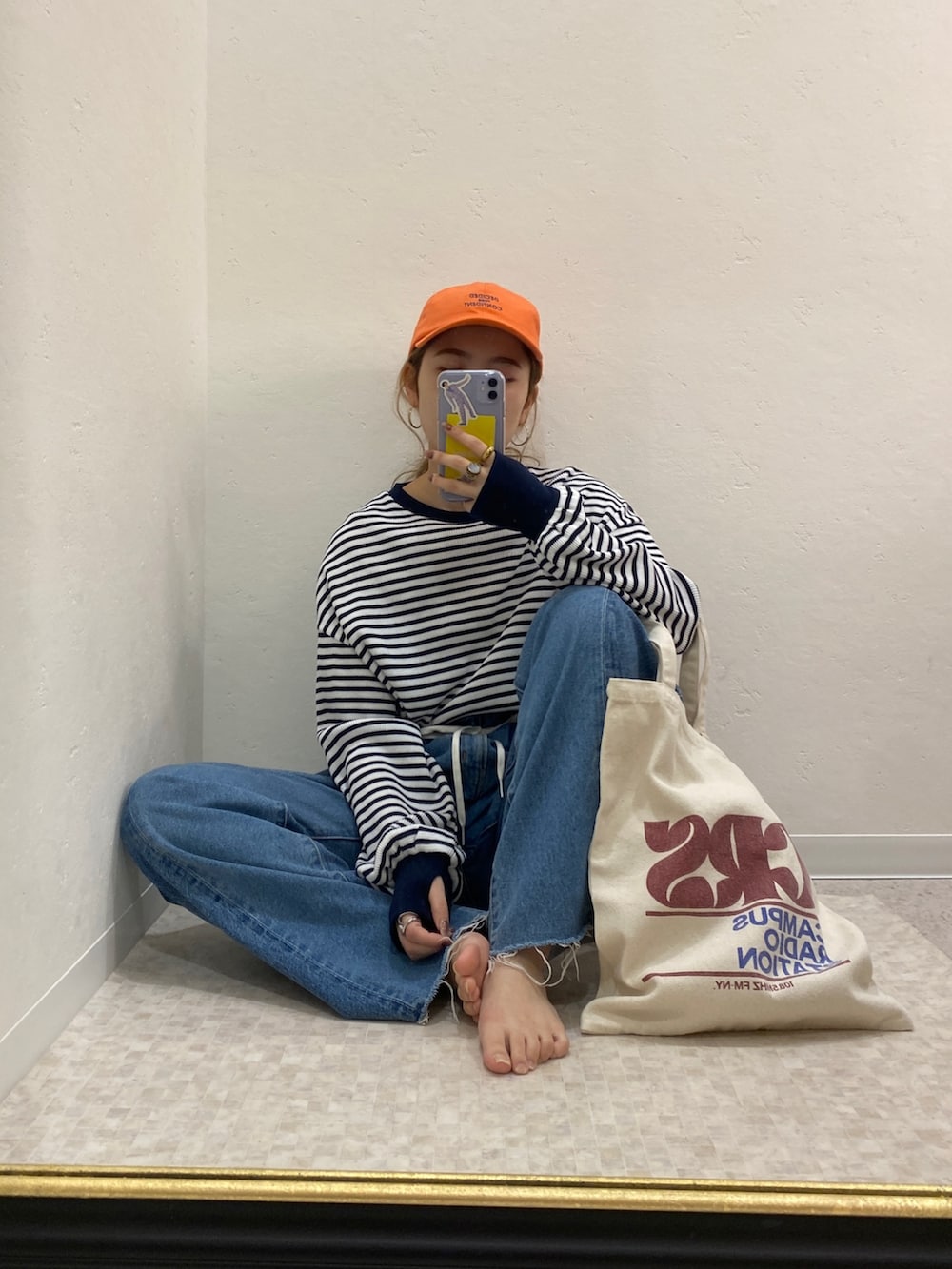 ブルー系のTシャツ/カットソー、ブルー系のデニムパンツ、レッド系のトートバッグを着用したレディースの冬コーディネートの6枚目の写真