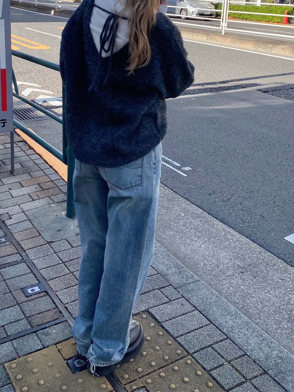 グレー系のニット/セーター、ブルー系のデニムパンツ、ブラック系のブーツを着用したレディースの冬コーディネートの4枚目の写真