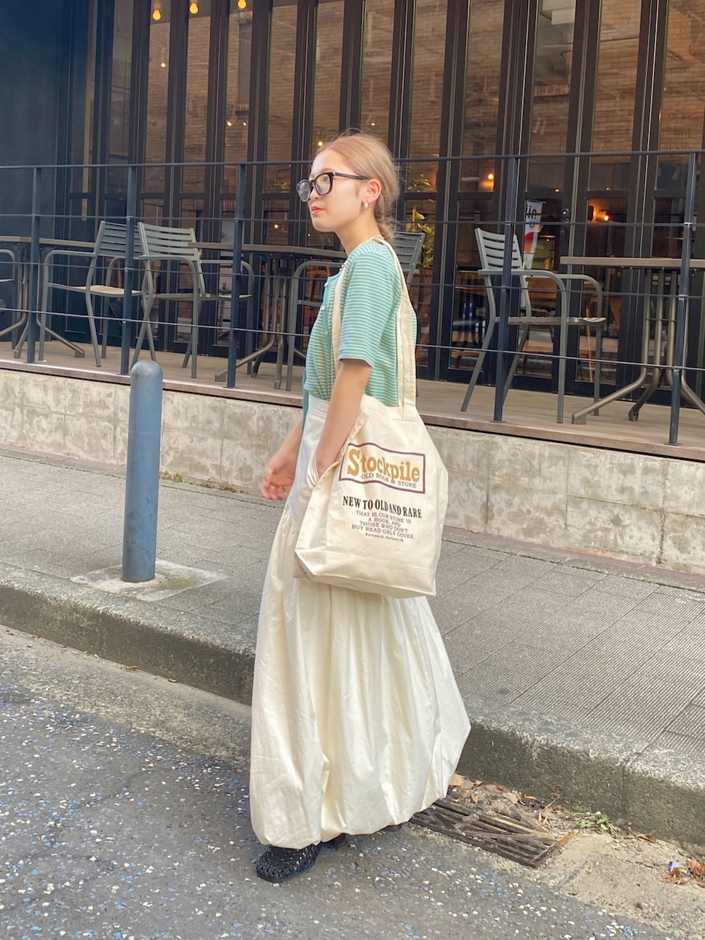 イエロー系のキャミソール、ホワイト系のスカートを着用したレディースの秋コーディネートの5枚目の写真