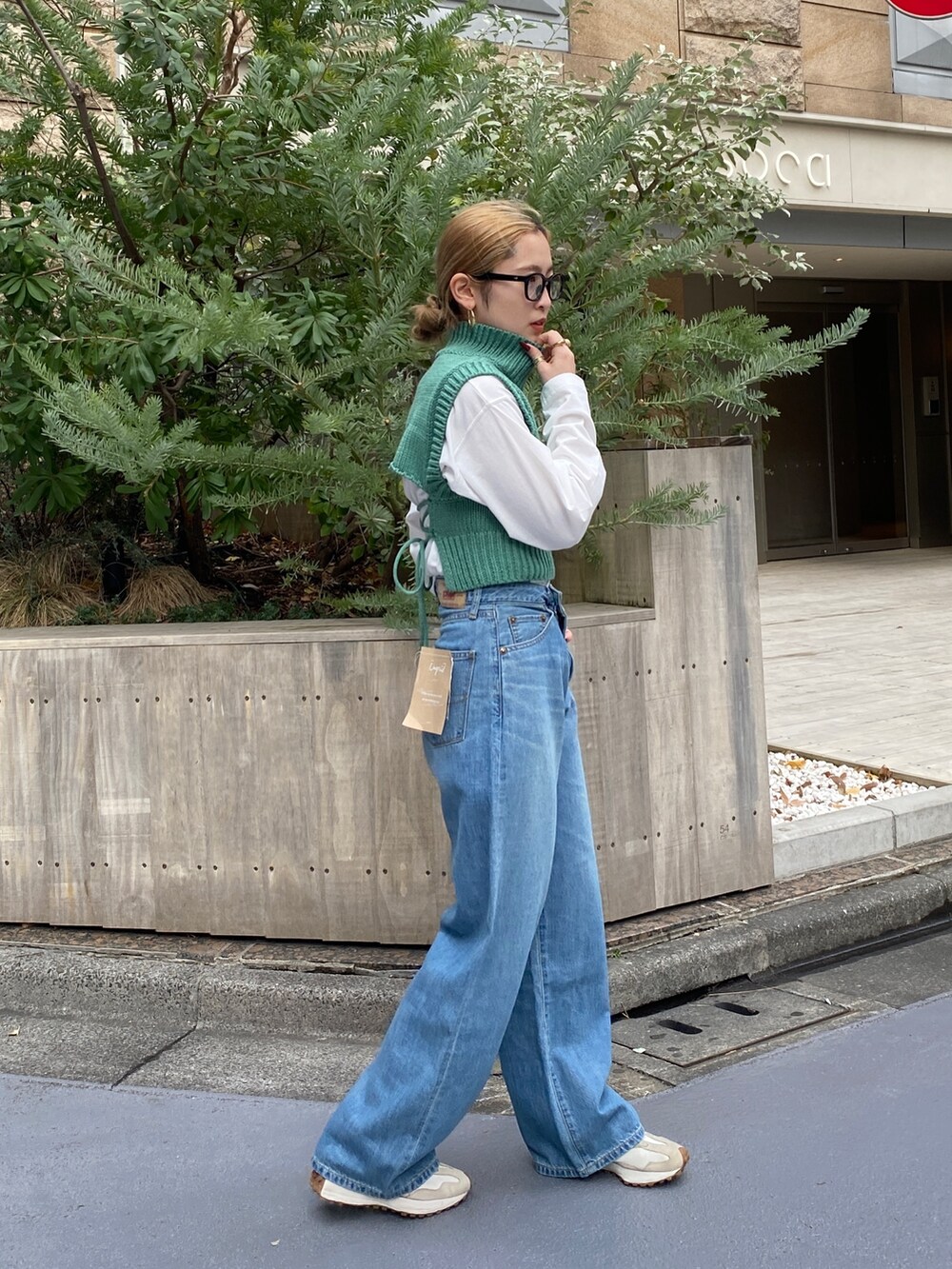 ブルー系のデニムパンツ、グリーン系のワンピースを着用したレディースの冬コーディネートの6枚目の写真