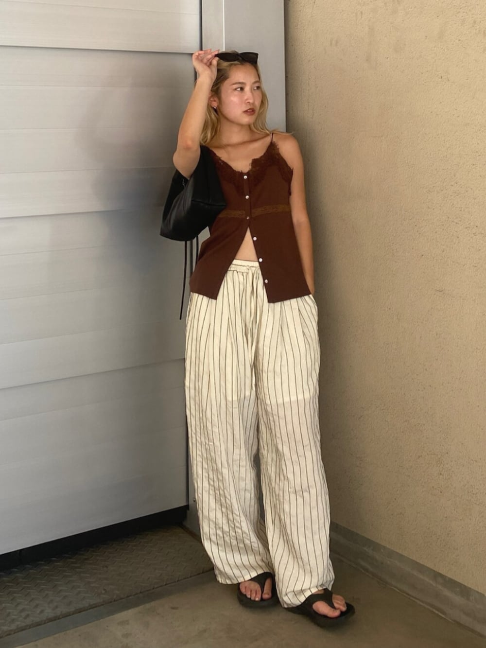 ホワイト系のその他パンツ、ブラウン系のTシャツ/カットソー、ブラック系のハンドバッグを着用したレディースの夏コーディネートの4枚目の写真