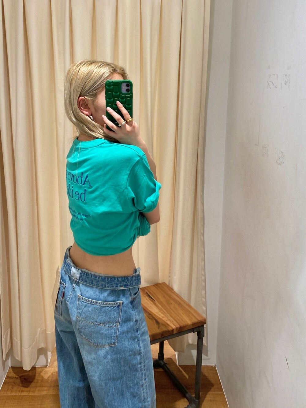 グリーン系のTシャツ/カットソー、ブルー系のデニムパンツを着用したレディースの春コーディネートの4枚目の写真