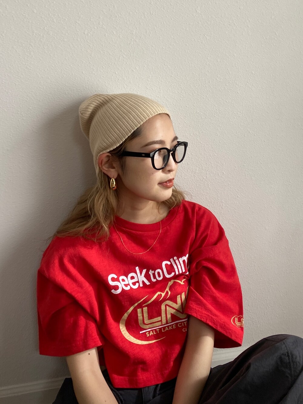 レッド系のTシャツ/カットソー、グレー系のその他パンツ、ホワイト系のサンダルを着用したレディースの冬コーディネートの4枚目の写真