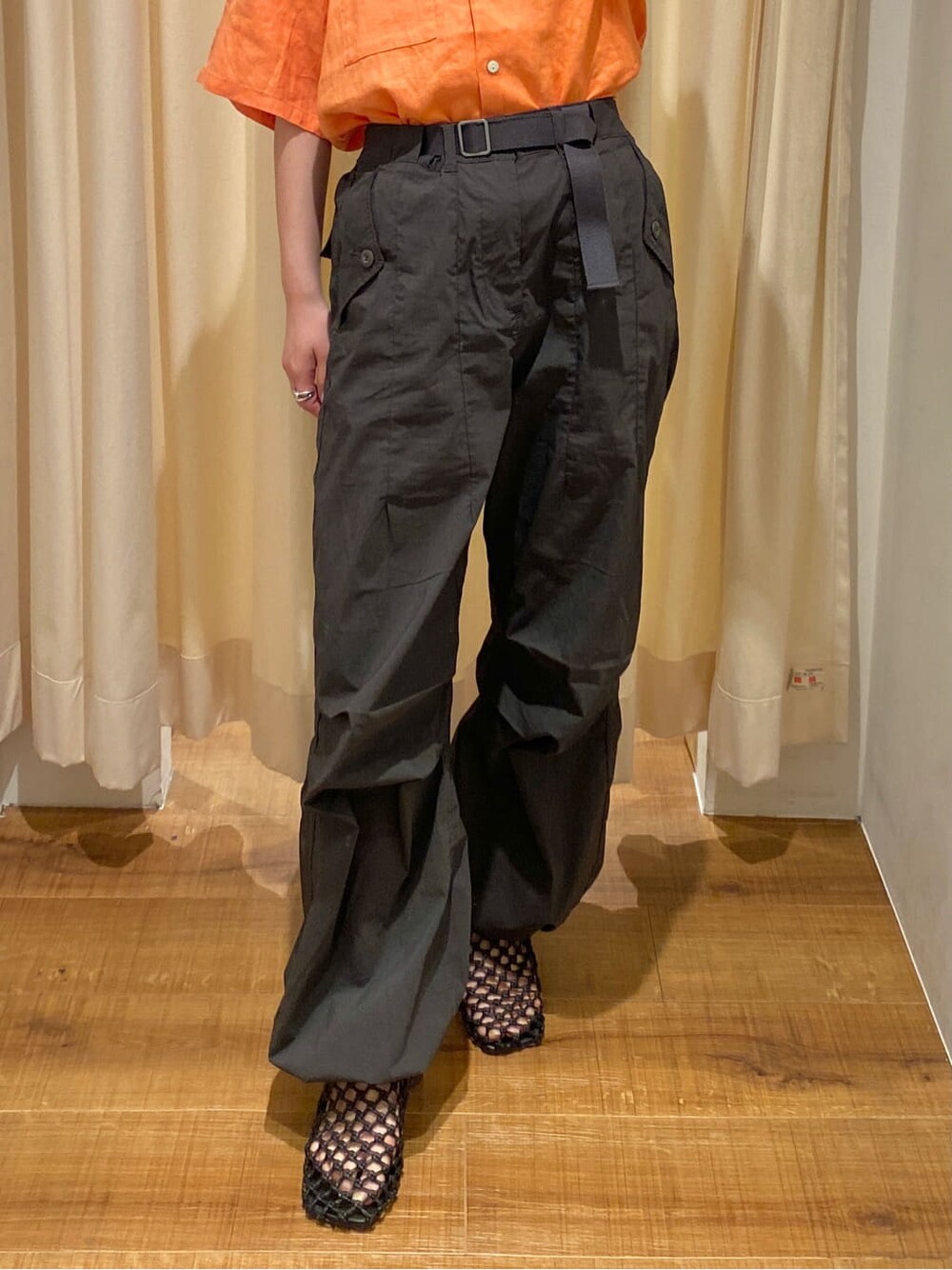 ブラック系のサンダル、ホワイト系のニット/セーター、オレンジ系のシャツ/ブラウスを着用したレディースの春コーディネートの5枚目の写真