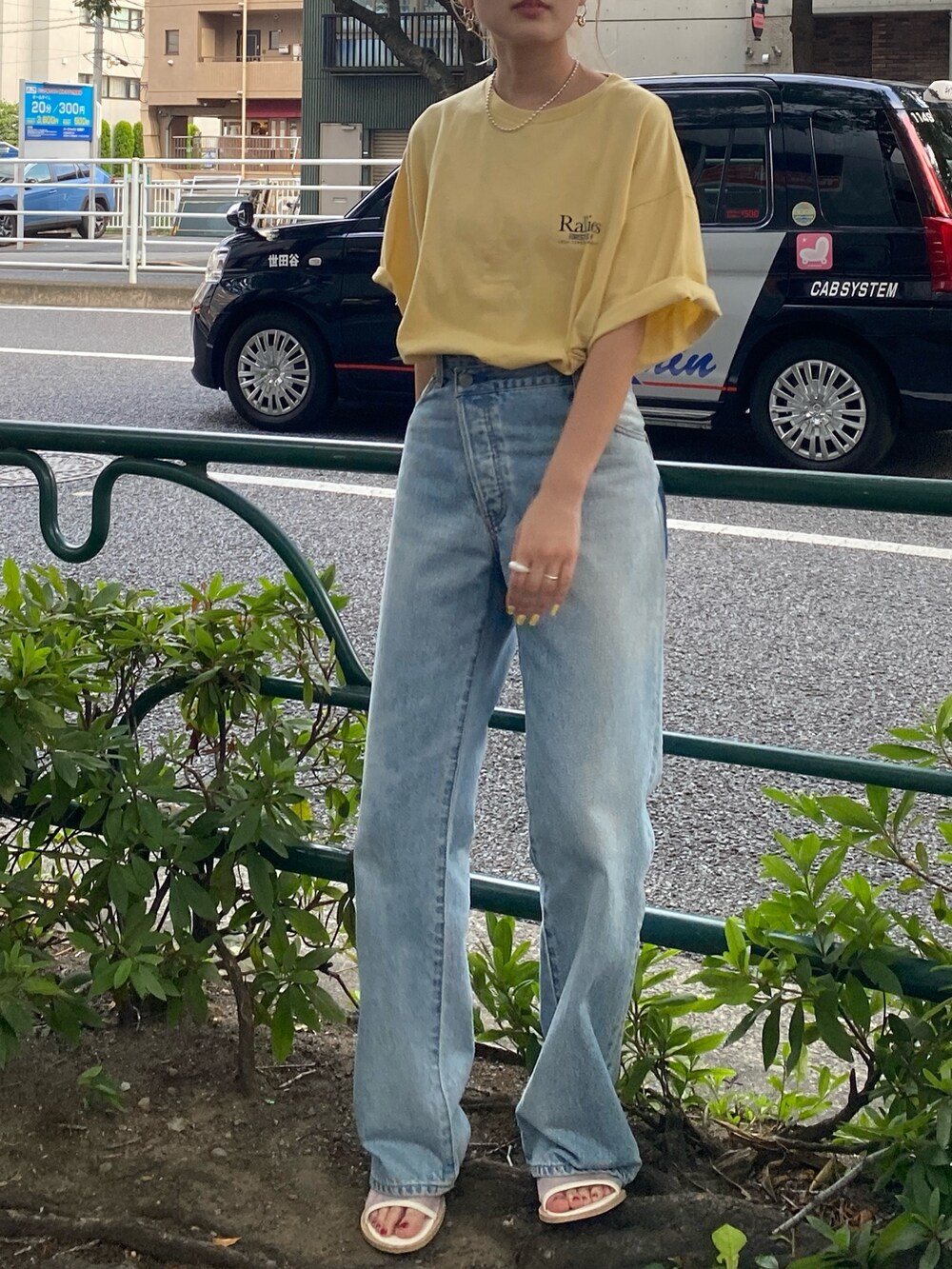 イエロー系のTシャツ/カットソー、ブルー系のデニムパンツを着用したレディースの夏コーディネートの2枚目の写真