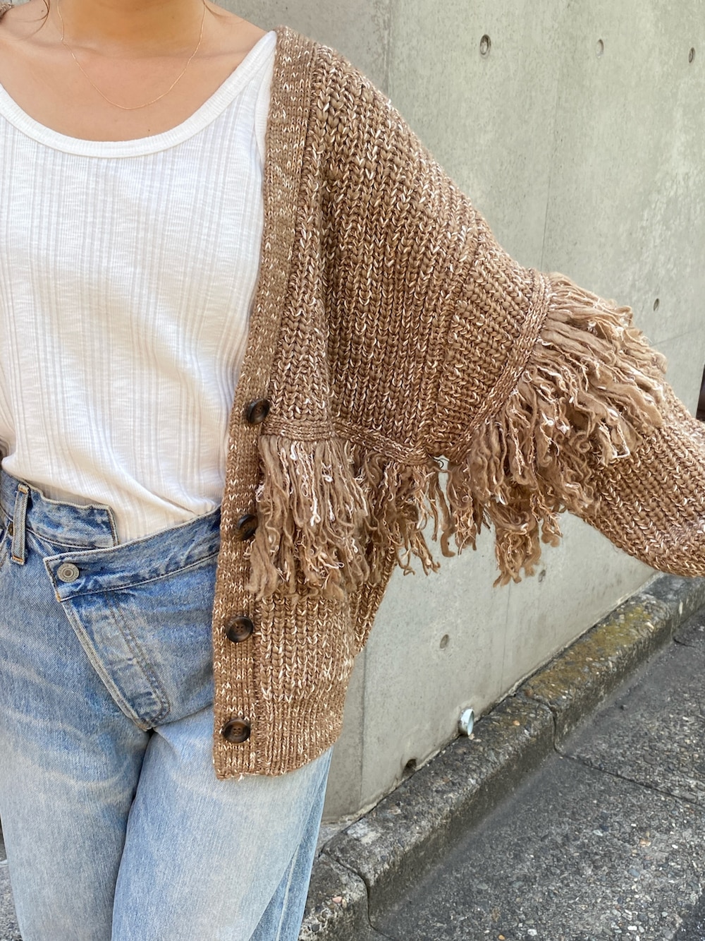 ブラウン系のカーディガン/ボレロ、ブルー系のデニムパンツ、ブラウン系のブーツを着用したレディースの冬コーディネートの2枚目の写真