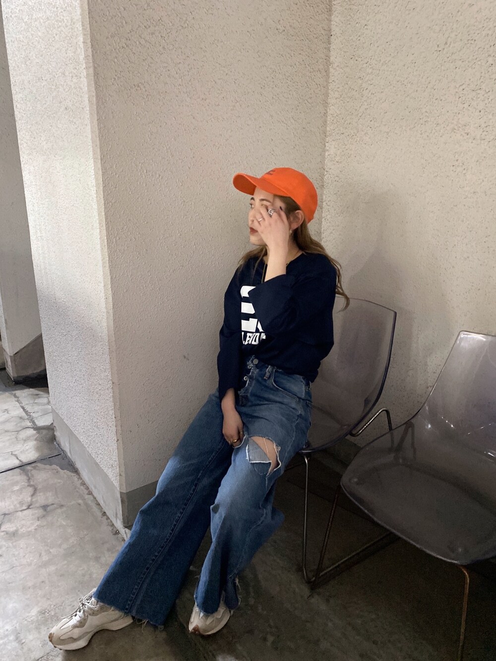 ブルー系のTシャツ/カットソー、ブルー系のデニムパンツ、オレンジ系のキャップを着用したレディースの春コーディネートの2枚目の写真