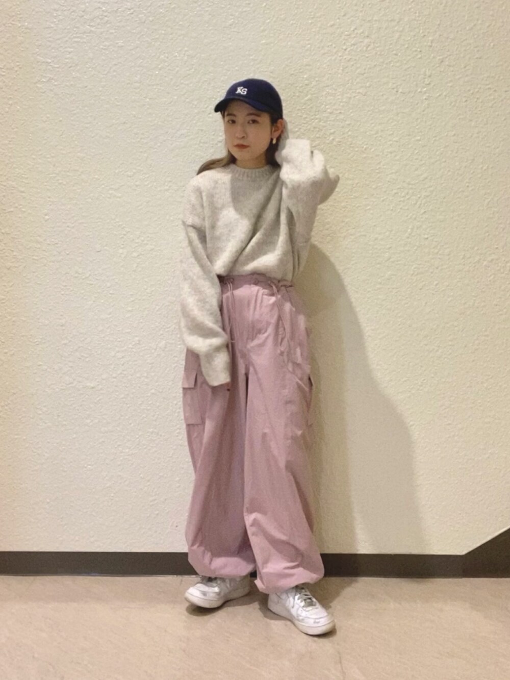ホワイト系のニット/セーター、ピンク系のカーゴパンツ、ブルー系のキャップを着用したレディースの冬コーディネートの2枚目の写真