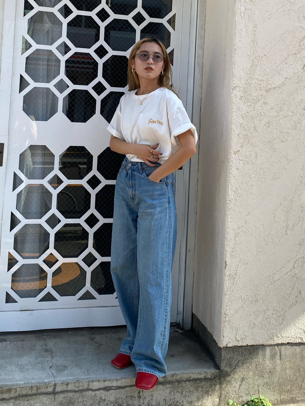 ホワイト系のTシャツ/カットソー、ブルー系のデニムパンツ、レッド系のローファーを着用したレディースの夏コーディネートの3枚目の写真