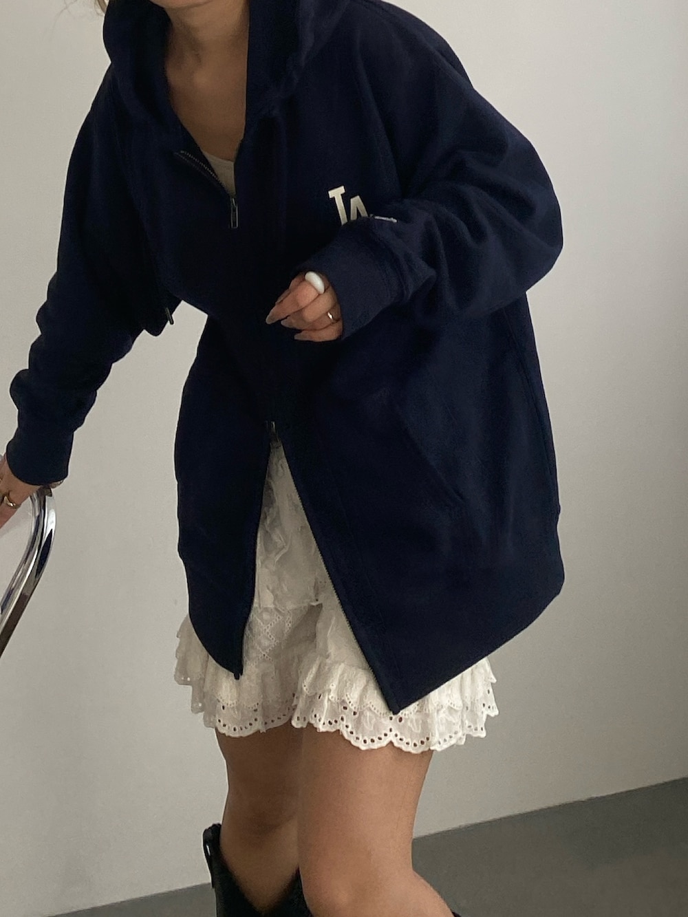 ブルー系のパーカー、ホワイト系のその他パンツ、ブラック系のブーツを着用したレディースの春コーディネートの3枚目の写真