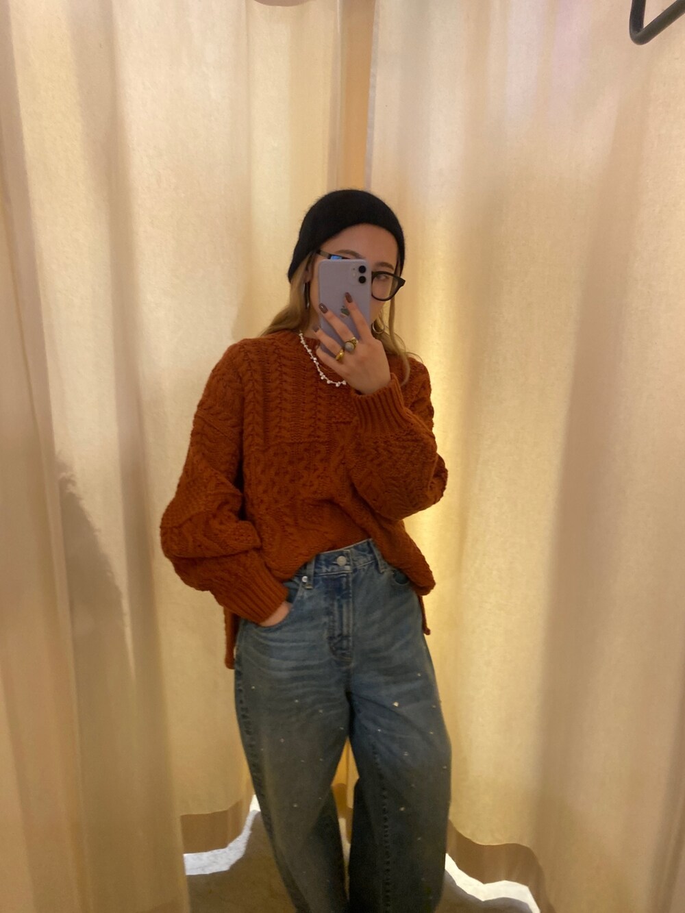 オレンジ系のニット/セーター、ブルー系のデニムパンツ、ブラック系のニットキャップ/ビーニーを着用したレディースの秋コーディネートの2枚目の写真