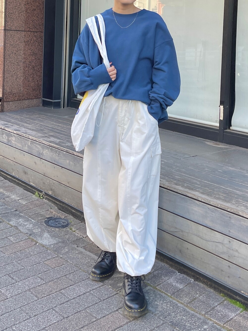 ホワイト系のカーゴパンツ、ブルー系のスウェット、ホワイト系のエコバッグ/サブバッグを着用したレディースの冬コーディネートの2枚目の写真