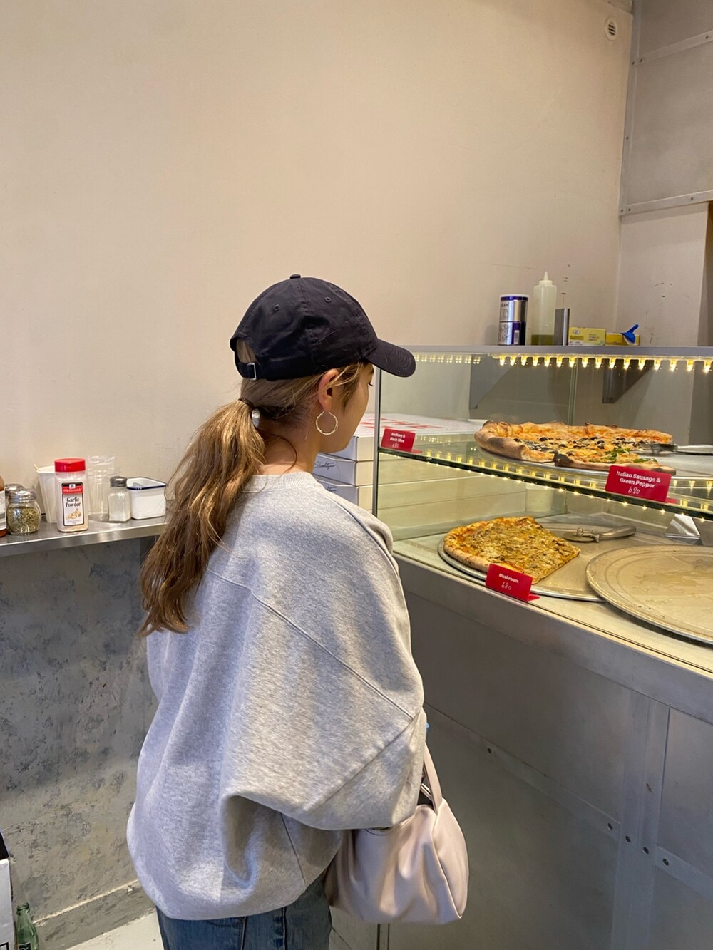 グレー系のスウェット、ブルー系のデニムパンツを着用したレディースの冬コーディネートの3枚目の写真