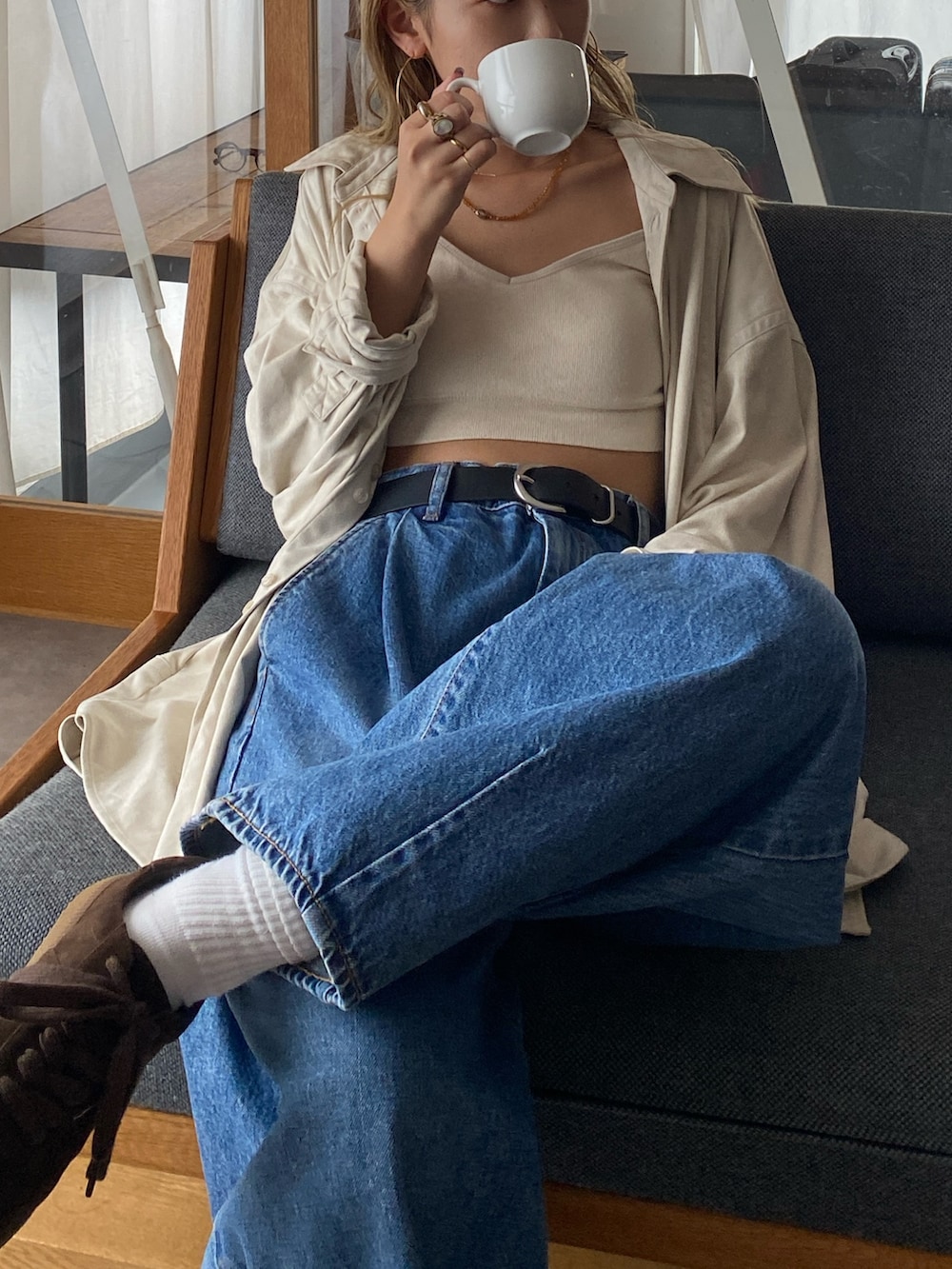 ホワイト系のシャツ/ブラウス、ブルー系のデニムパンツ、ブラウン系のスニーカーを着用したレディースの秋コーディネートの3枚目の写真