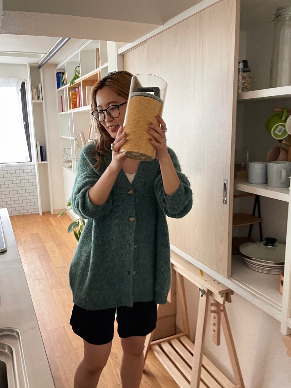 グリーン系のカーディガン/ボレロ、ブラック系のローファー、ブラック系のメガネを着用したレディースの秋コーディネートの3枚目の写真