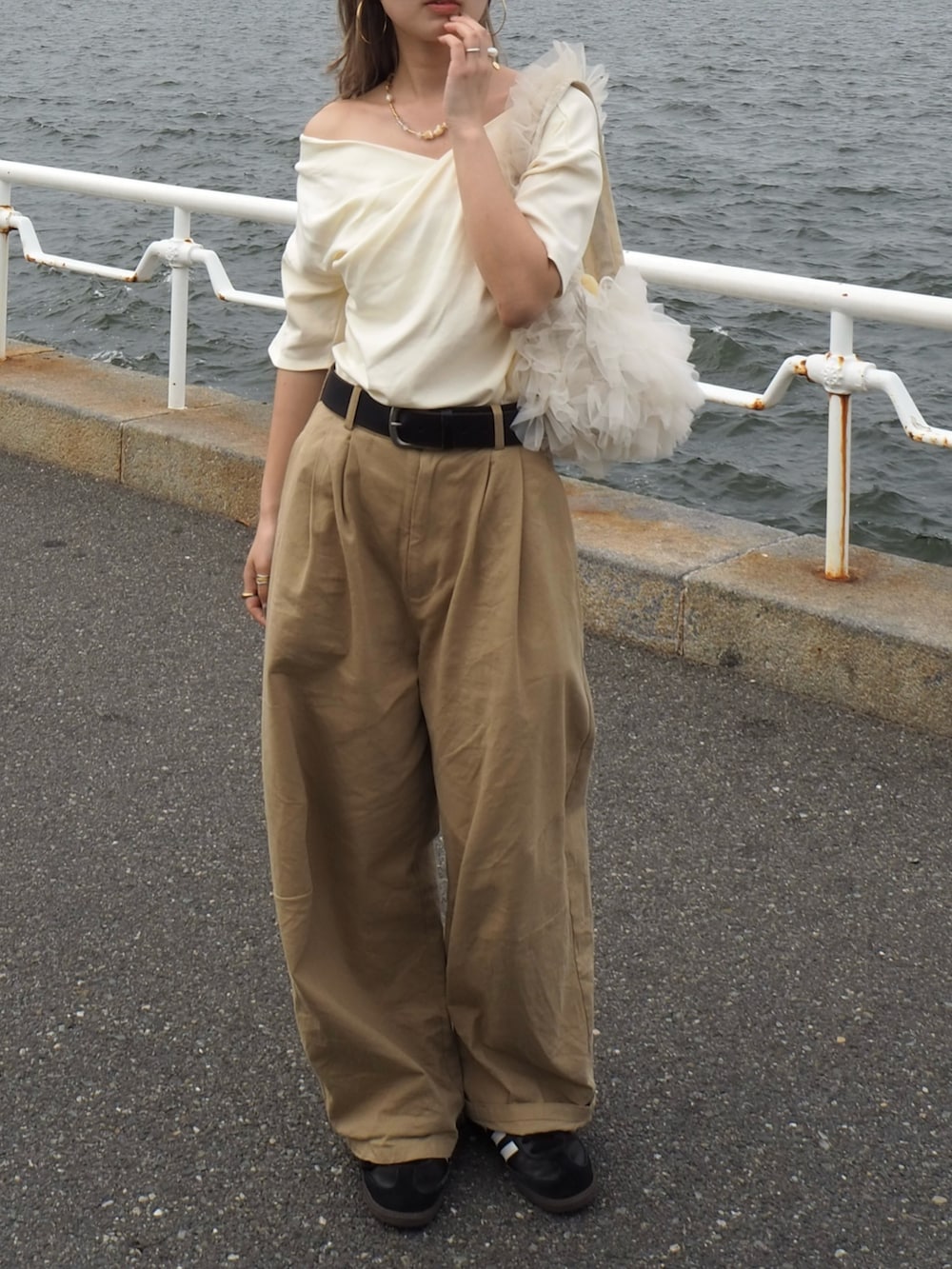 ホワイト系のTシャツ/カットソー、ベージュ系のチノパンツ、ホワイト系のショルダーバッグを着用したレディースの春コーディネートの2枚目の写真
