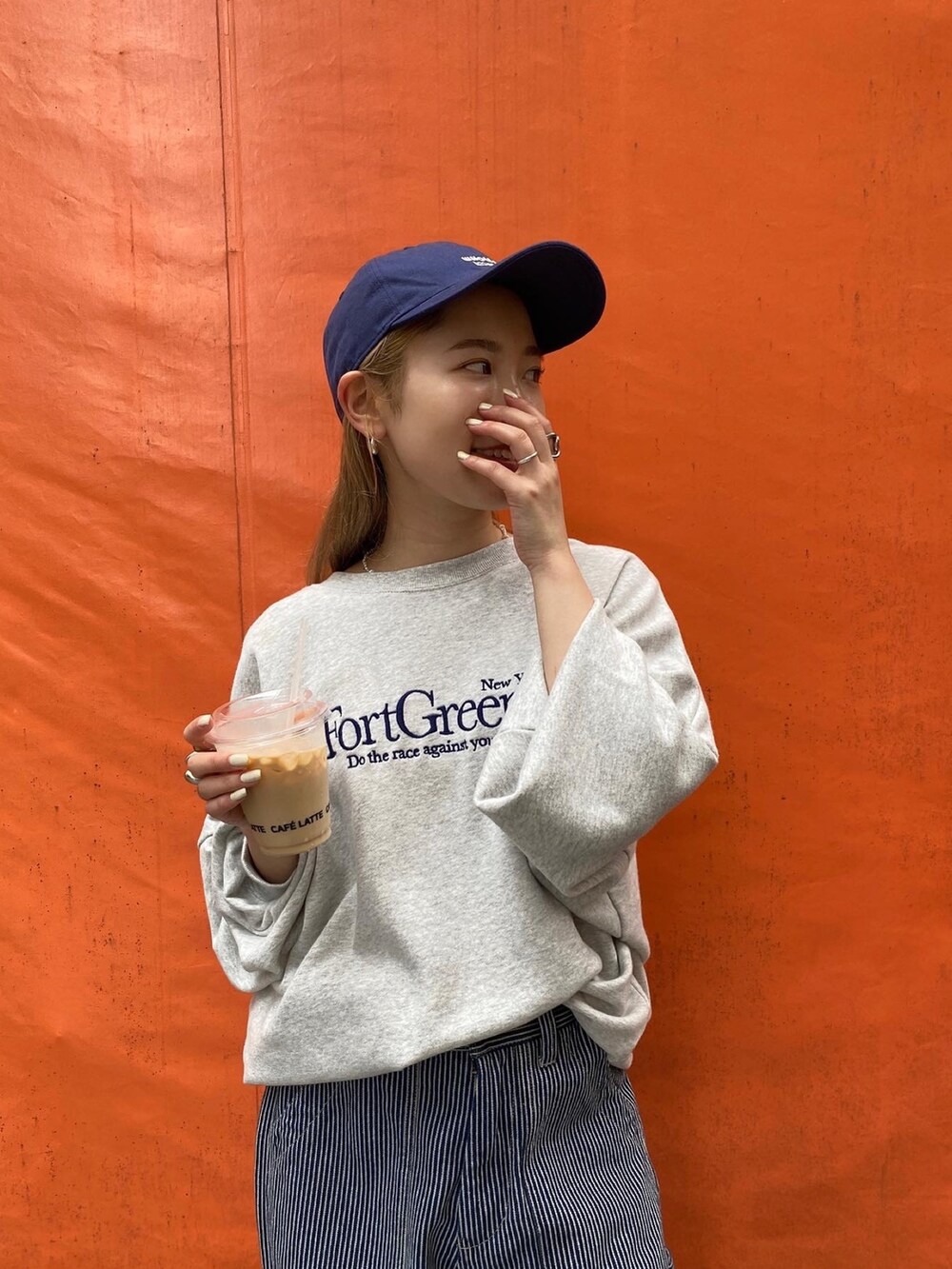 グレー系のスウェット、その他のデニムパンツ、ブルー系のキャップを着用したレディースの夏コーディネートの2枚目の写真