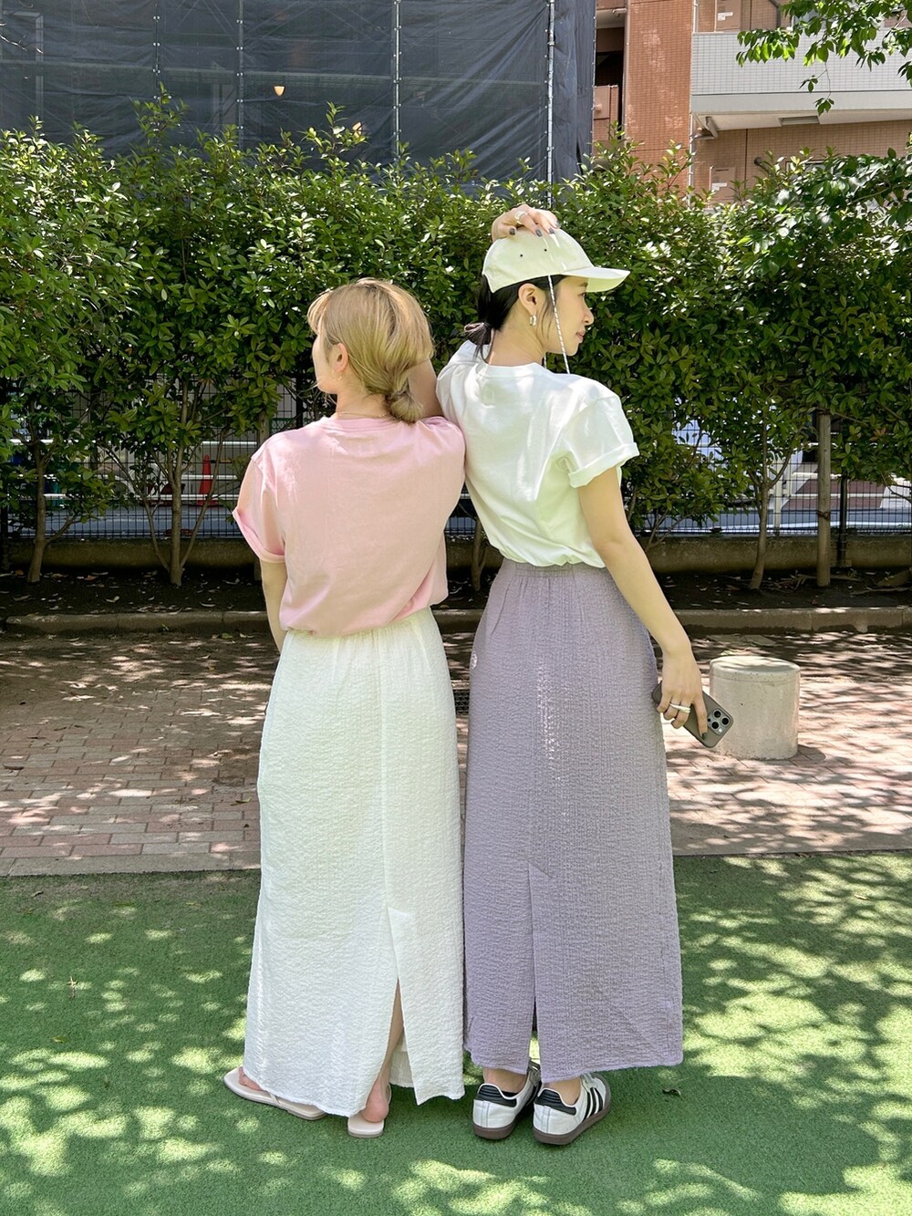 ピンク系のTシャツ/カットソー、ホワイト系のスカートを着用したレディースの夏コーディネートの4枚目の写真