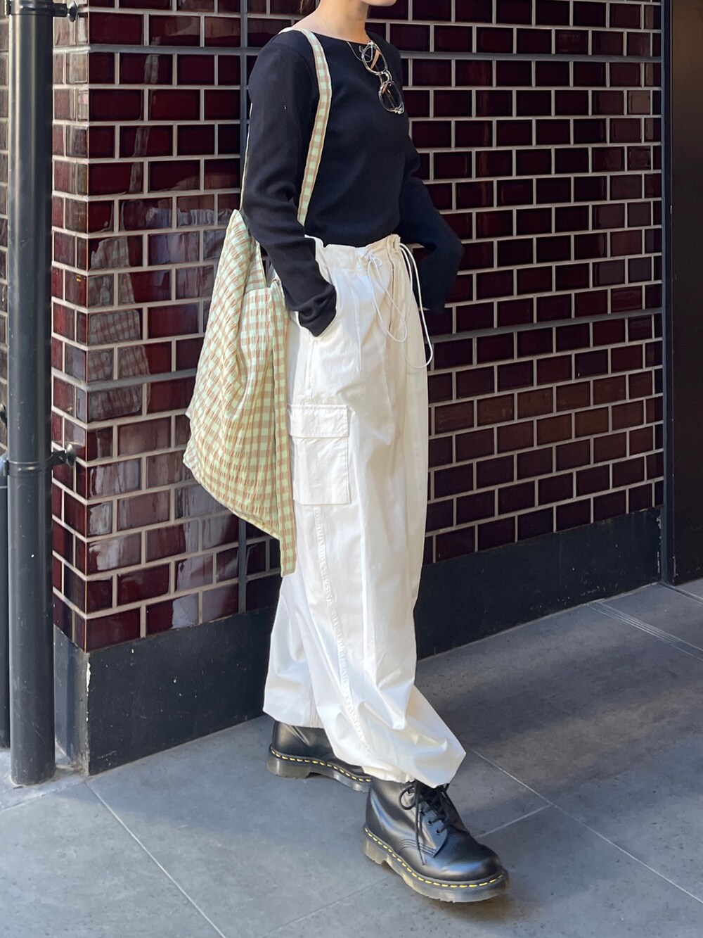 ブラック系のTシャツ/カットソー、ホワイト系のカーゴパンツ、グリーン系のショルダーバッグを着用したレディースの春コーディネートの5枚目の写真