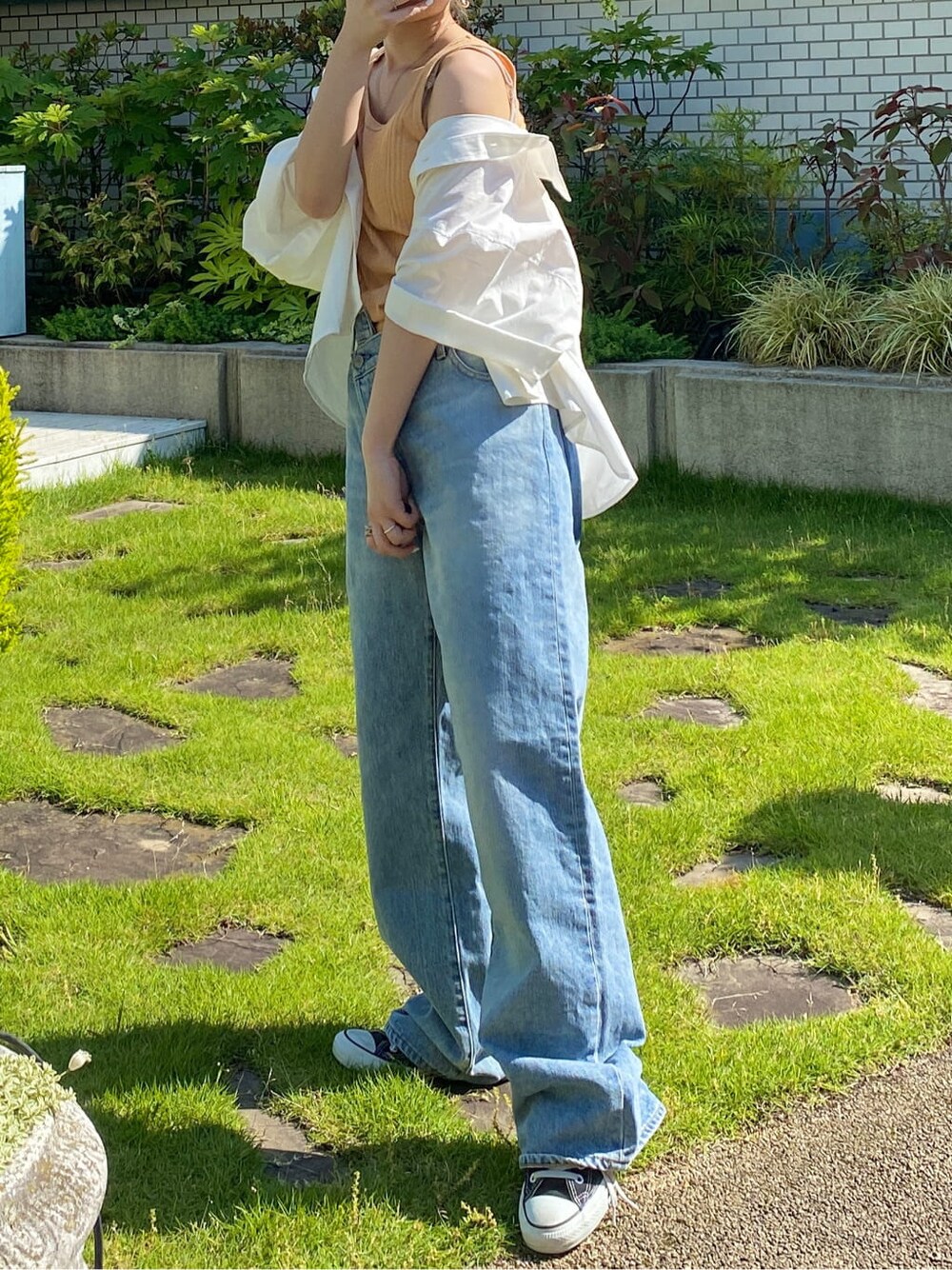 ホワイト系のシャツ/ブラウス、ブルー系のデニムパンツ、オレンジ系のタンクトップを着用したレディースの春コーディネートの2枚目の写真