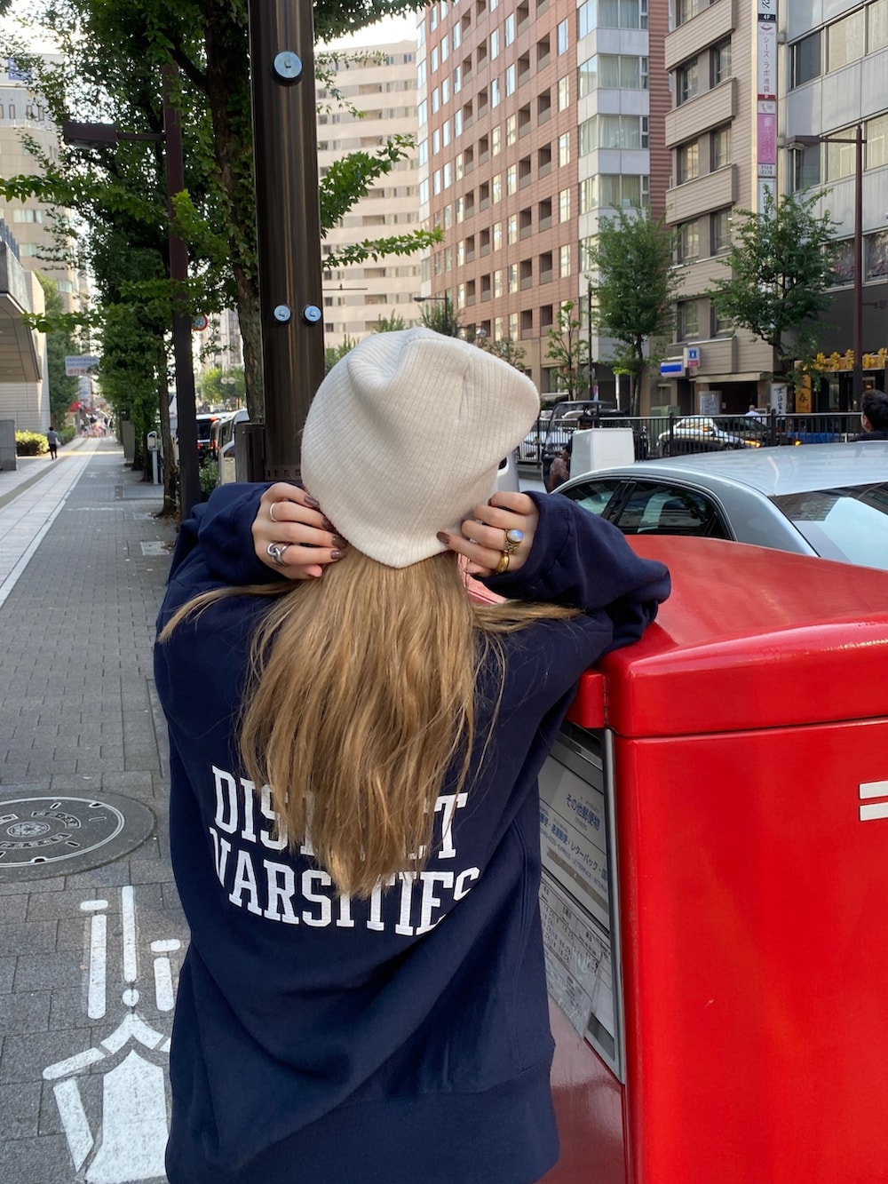 ブルー系のスウェット、ブルー系のデニムパンツ、ホワイト系のニットキャップ/ビーニーを着用したレディースの秋コーディネートの2枚目の写真