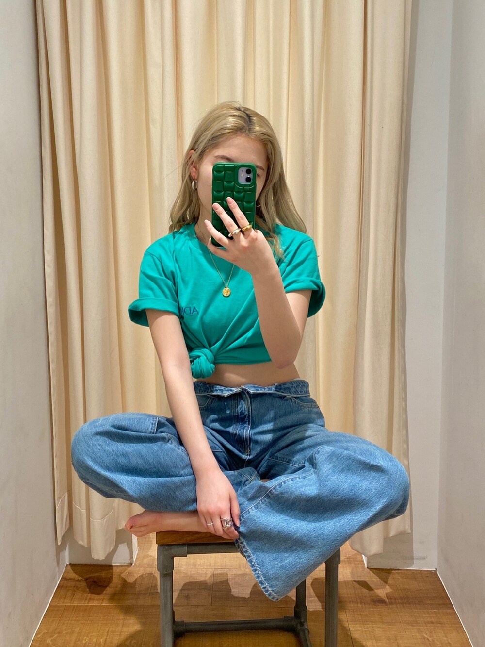 グリーン系のTシャツ/カットソー、ブルー系のデニムパンツを着用したレディースの春コーディネートの3枚目の写真